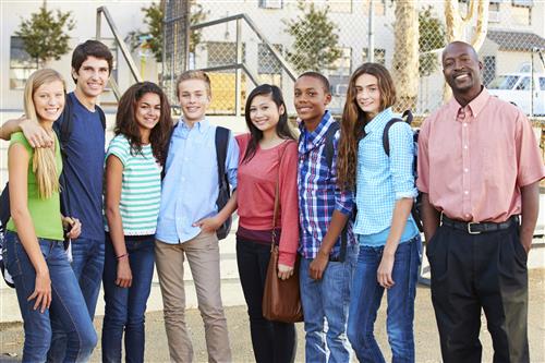 Teacher standing with students and smiling